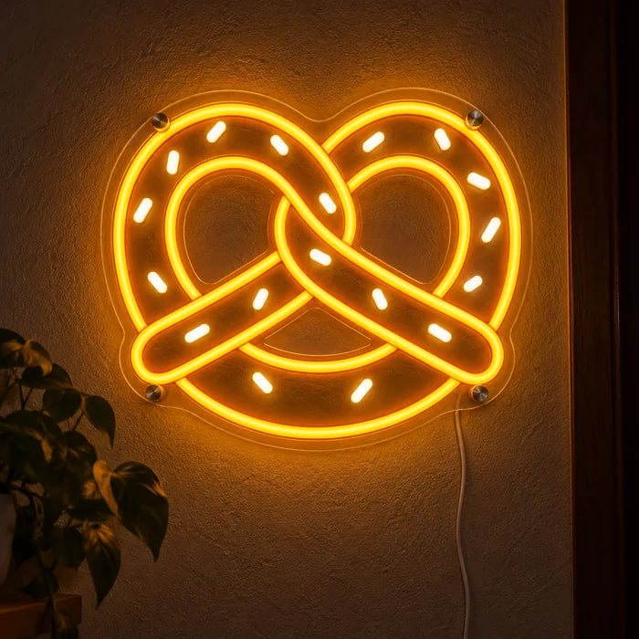 Golden Pretzel Neon LED Sign glowing on a dark wall, close-up with connection cable