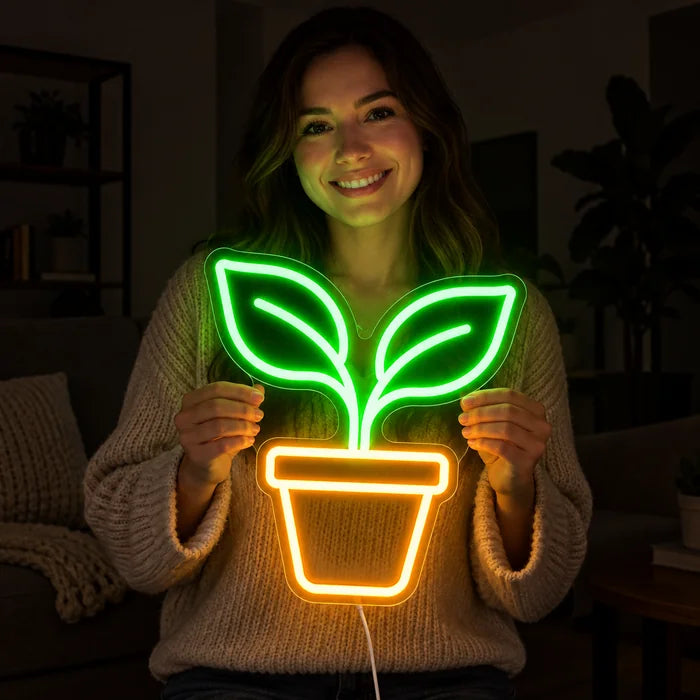 Little Sprout Neon LED Sign held by a smiling woman against a dark background
