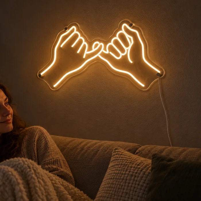 Pinky Promise Neon LED Sign on a living room wall, a person relaxing on the sofa in front of it