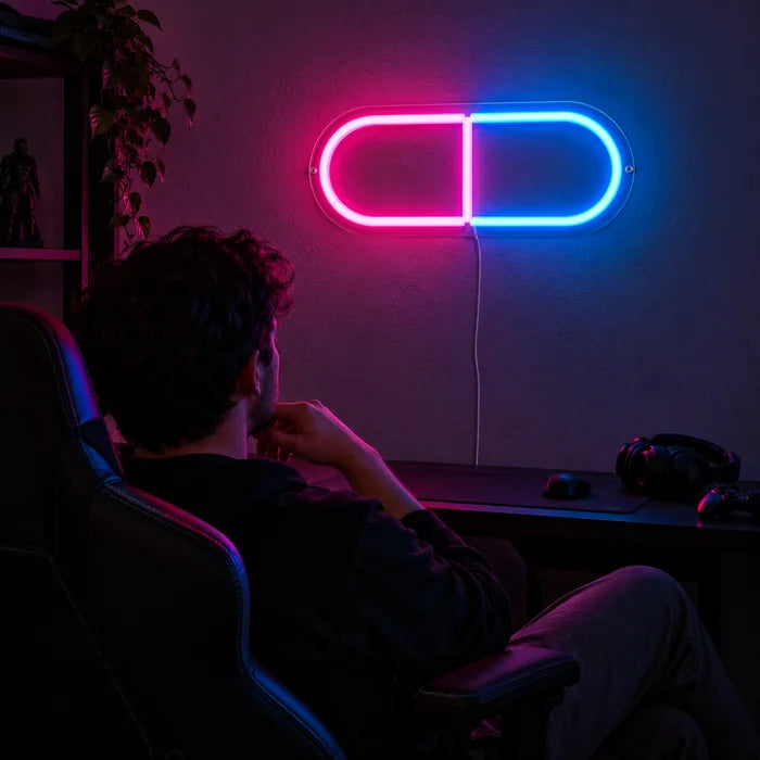 Neonová LED cedule Kapsle léku nad herním stolem, před ní hráč v herní židli