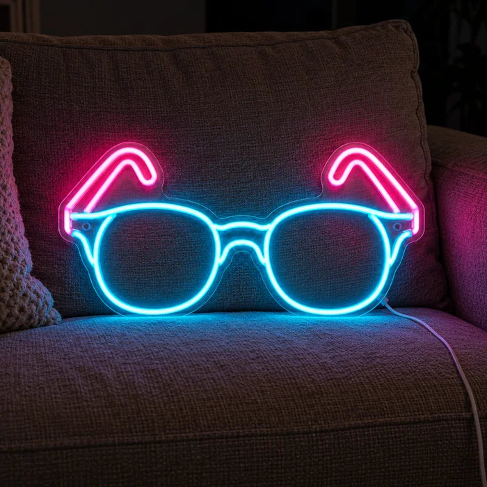 Neonlasit neon LED -kyltti kodikkaalla sohvalla tyynyjen ja huovan välissä