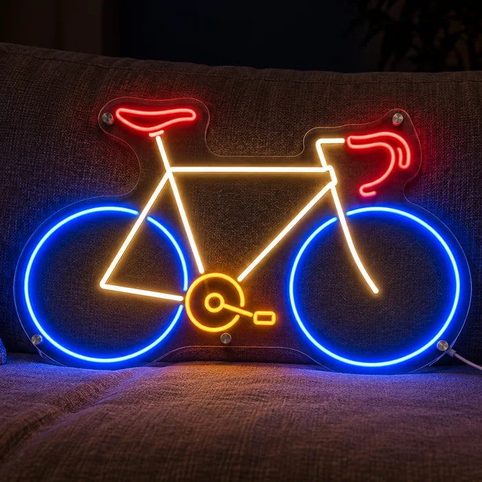 Neon Road Bike Neon LED Sign on a cosy sofa between cushions and a throw