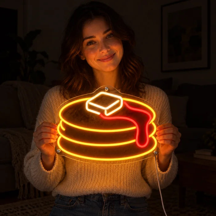 Pancakes Neon LED Sign held by a smiling woman against a dark background
