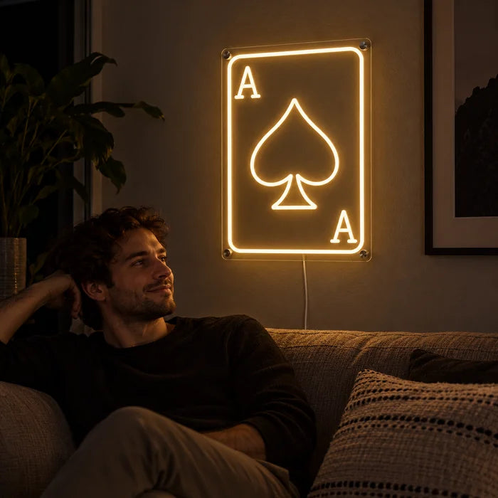 Maça ası neon LED tabela, oturma odası duvarında, önünde kanepede dinlenen bir kişi
