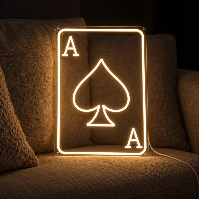 Maça ası neon LED tabela, yastıklar ve battaniye arasında rahat bir kanepede