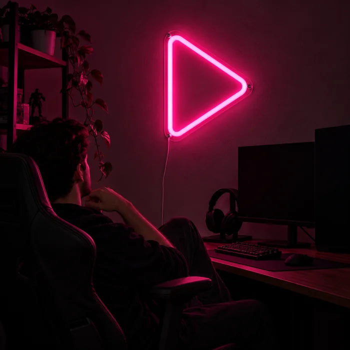 Play Button Neon LED Sign above a gaming desk, a gamer in a gaming chair in front of it