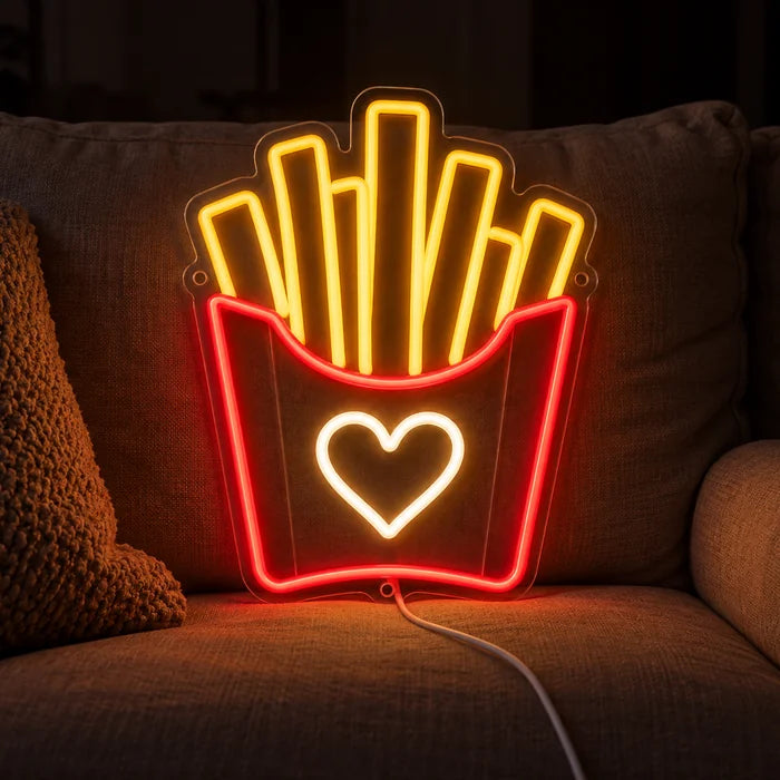 Fries Love Neon LED Sign on a cosy sofa between cushions and a throw
