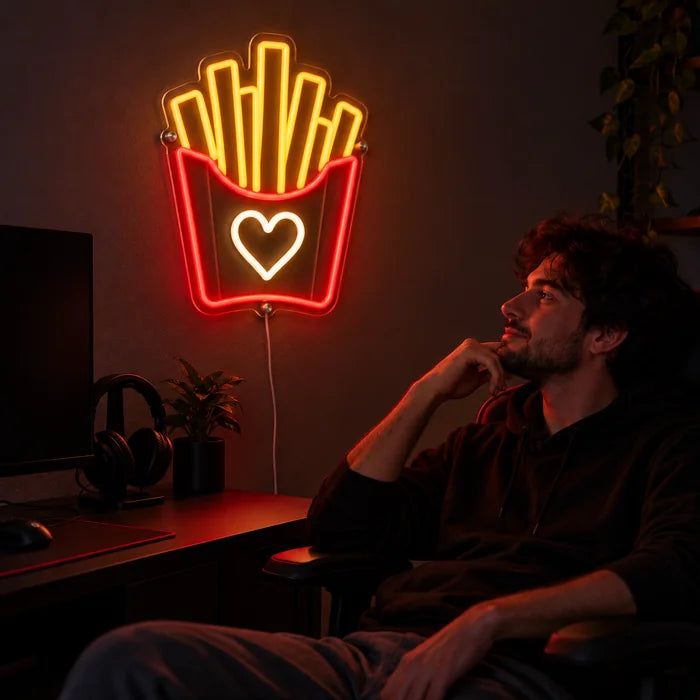 Fries Love Neon LED Sign above a gaming desk, a gamer in a gaming chair in front of it