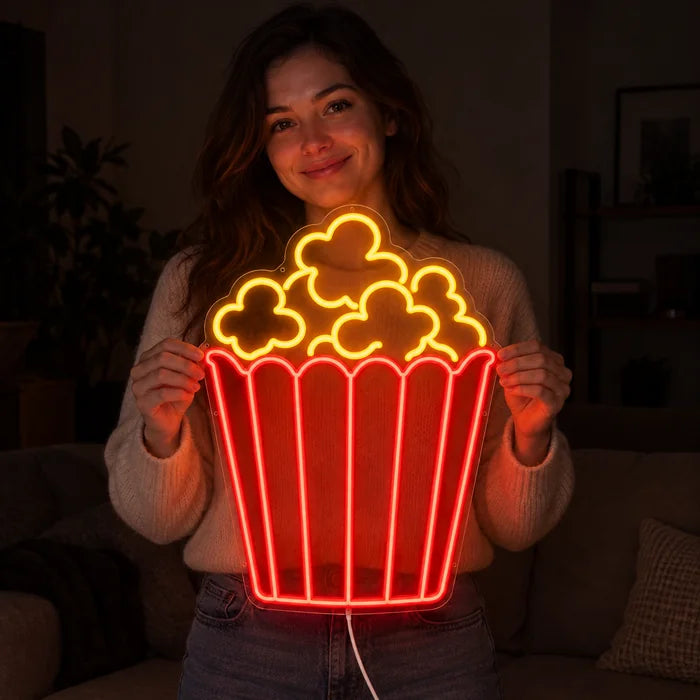 Popcorn Neon LED Sign held by a smiling woman against a dark background