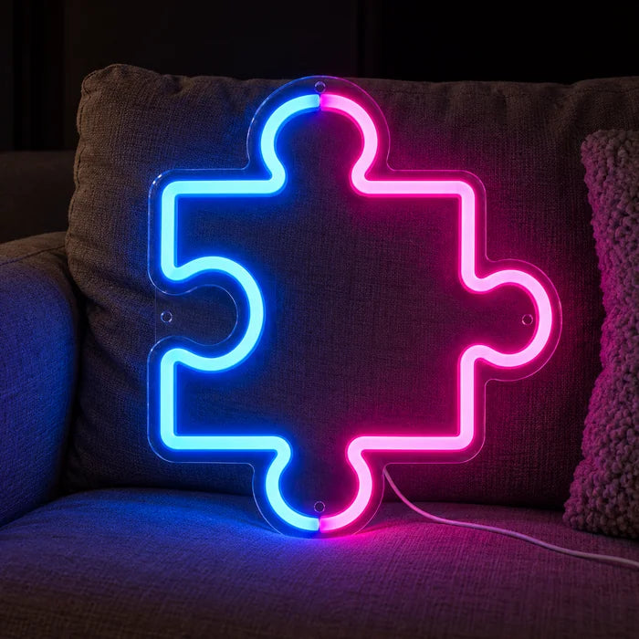 Neon LED bord Puzzelstuk op een gezellige bank tussen kussens en plaid