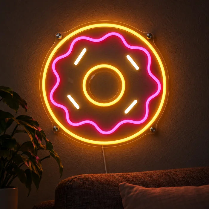 שלט ניאון LED דונאט ורוד זוהר על קיר כהה, תקריב עם כבל החיבור