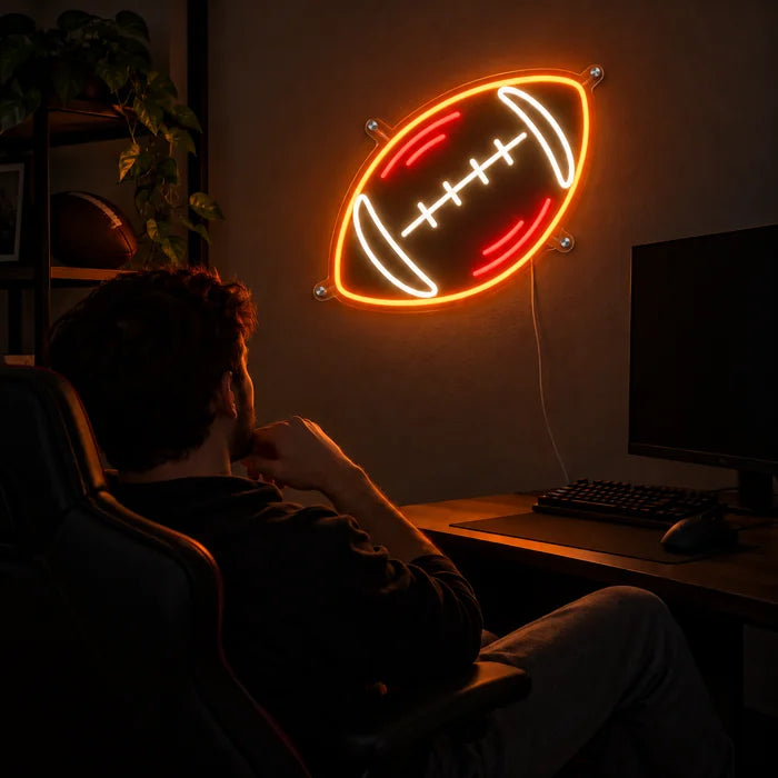 Rugbybold neon LED skilt over gaming-skrivebordet, foran en gamer i gamingstolen