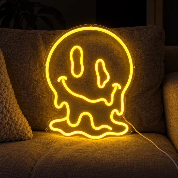 Melting Skull Neon LED Sign on a cosy sofa between cushions and a throw