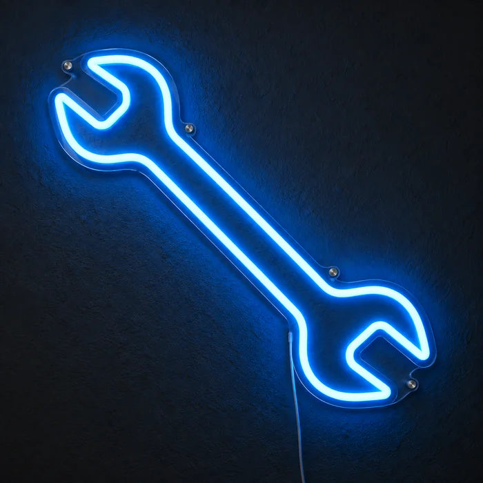 Neon LED bord Steeksleutel, oplichtend aan een donkere wand, close-up met aansluitkabel