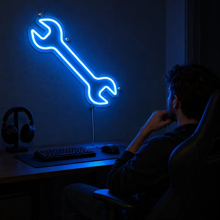 Neon LED bord Steeksleutel boven het gamingbureau, ervoor een speler in een gamingstoel