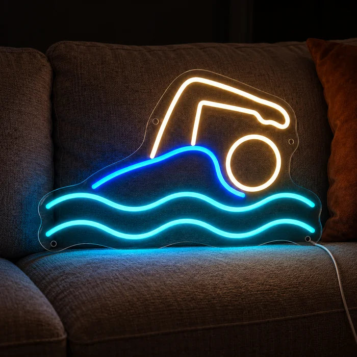 Swimmer Neon LED Sign on a cosy sofa between cushions and a throw