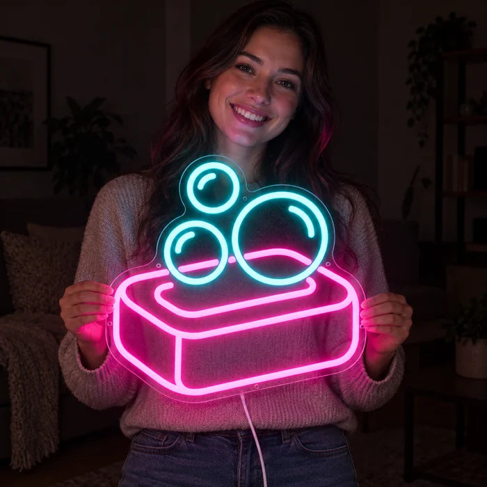 Soap Bubbles Neon LED Sign held by a smiling woman against a dark background