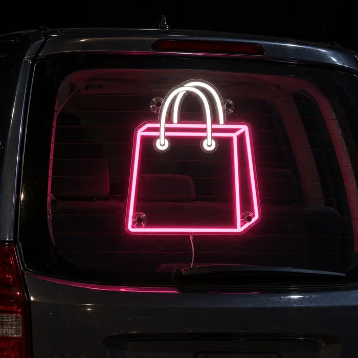 Shopping Bag Neon LED Sign on the rear window of a car at night