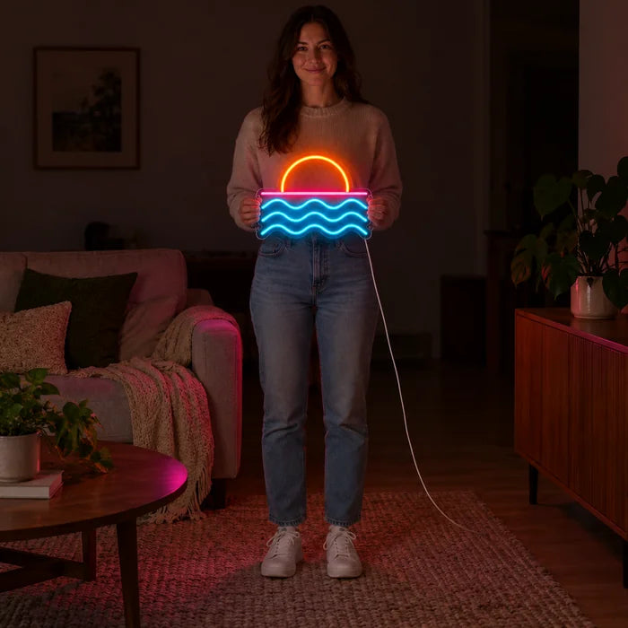 Auringonlasku meren yllä neon LED -kyltti naisen pitelemänä, näyttää koon vartaloon verrattuna