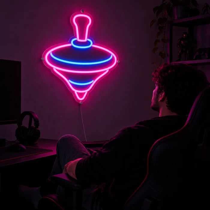 Spinning Top Neon LED Sign above a gaming desk, a gamer in a gaming chair in front of it