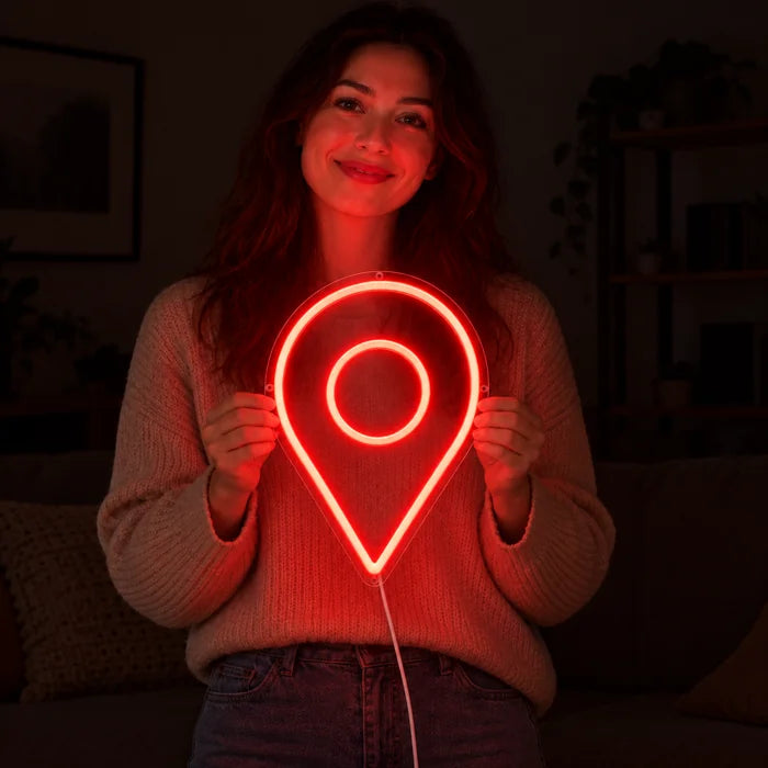Neonová LED cedule Značka polohy v rukou usmívající se ženy před tmavým pozadím