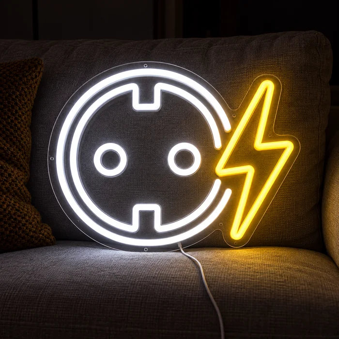 Socket with Lightning Bolt Neon LED Sign on a cosy sofa between cushions and a throw
