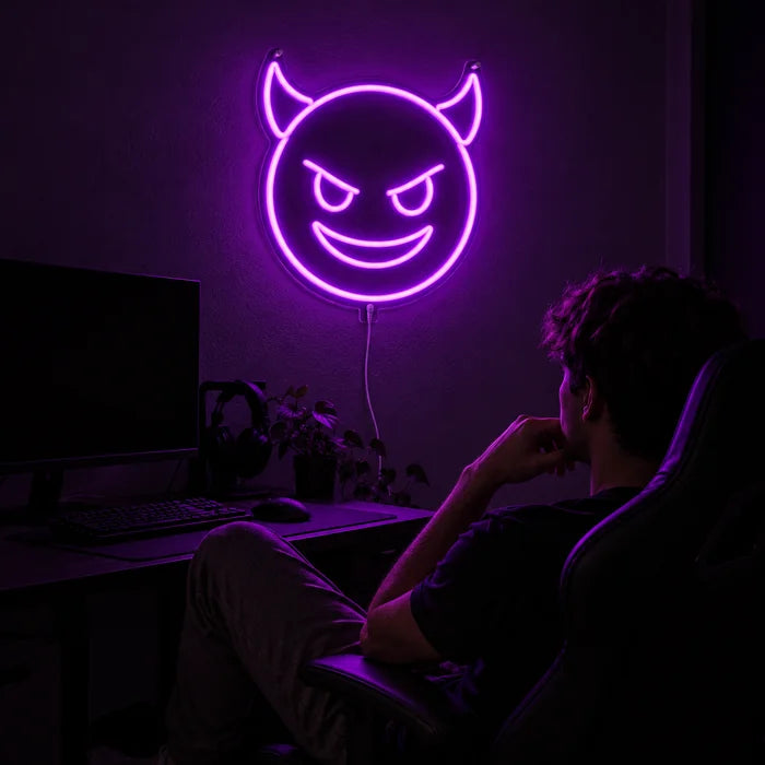 Devil Grin Neon LED Sign above a gaming desk, a gamer in a gaming chair in front of it