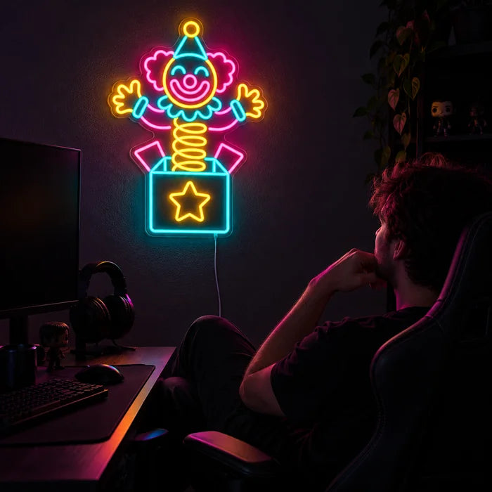 Surprise Clown Neon LED Sign above a gaming desk, a gamer in a gaming chair in front of it