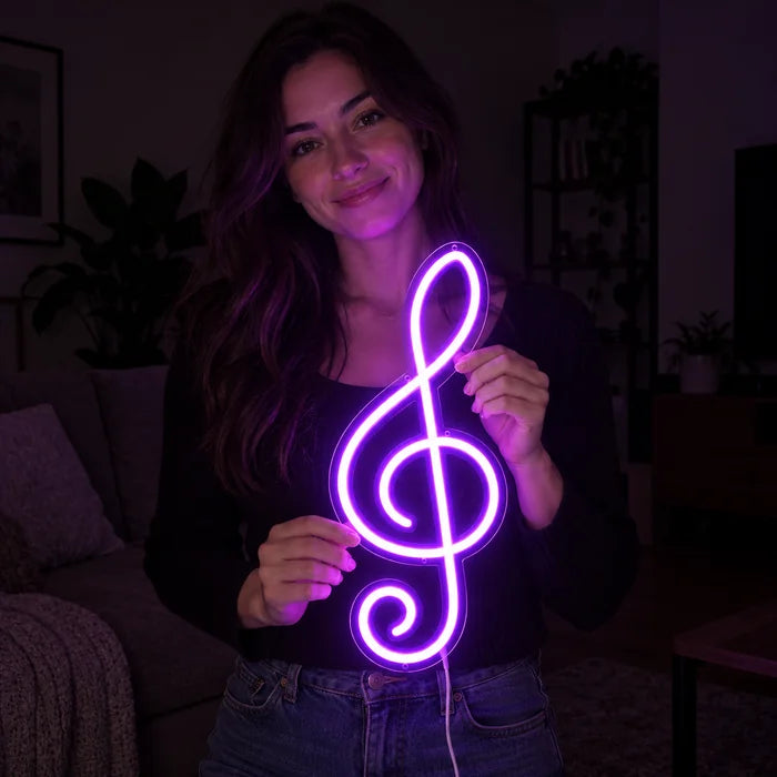Treble Clef Neon LED Sign held by a smiling woman against a dark background